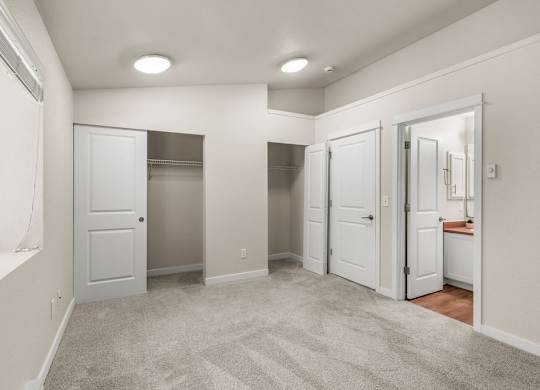 Spacious bedroom with walk-in closets and ensuite bathroom at Hidden River Townhomes Apartments, Washington