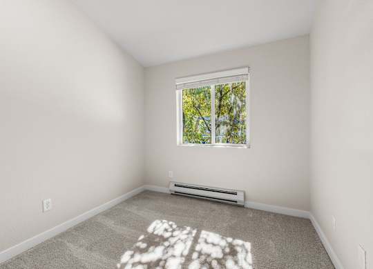 Empty bedroom with carpeted flooring and window at Hidden River Townhomes Apartments, Kirkland, WA