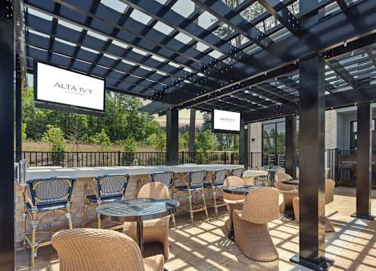 A patio with tables and chairs under a roof with