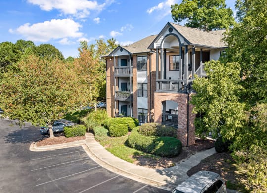 the view of an apartment building with a parking lot and trees at View at Lake Lynn, North Carolina, 27613