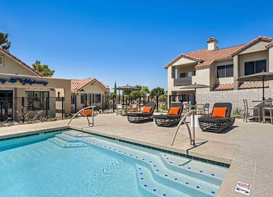 A swimming pool surrounded by lounge chairs and umbrellas.