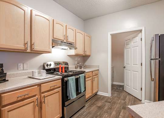 A kitchen with wooden cabinets and black appliances.