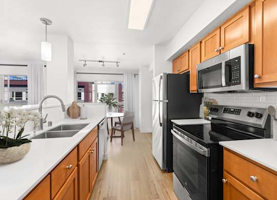 A kitchen with black appliances and wooden cabinets.