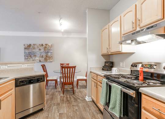 A kitchen with wooden cabinets and a stainless steel oven.