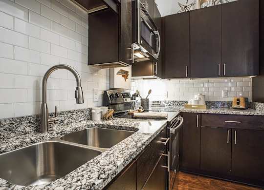 A kitchen with a sink and a microwave.