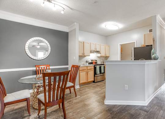 A kitchen with a dining table and chairs.