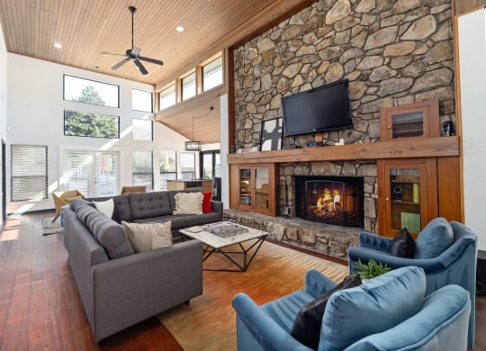 a large living room with a stone fireplace and couches
