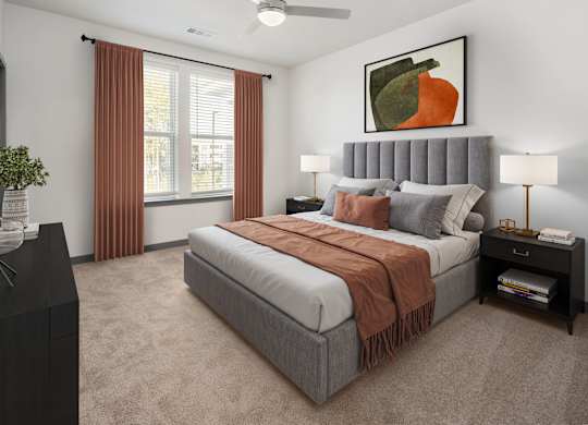 A bedroom with a large bed and a painting of a pumpkin on the wall.