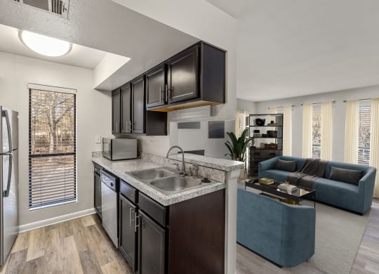 a kitchen and living room with a sink and a refrigerator