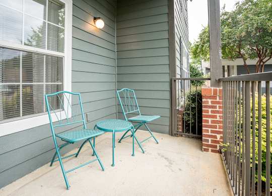 A blue chair and table set on a porch.