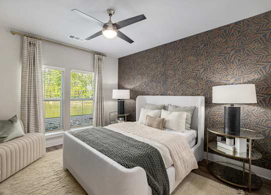 a bedroom with a large bed and a ceiling fan