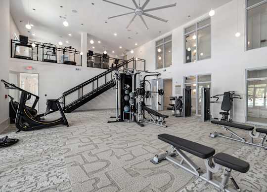 a gym with exercise equipment and a staircase