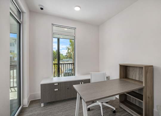 an office space with a desk and a chair and a window