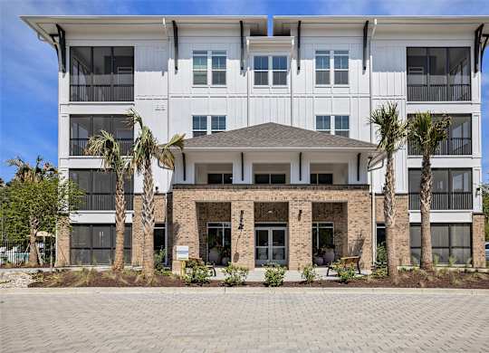 an image of a building with palm trees in front of it