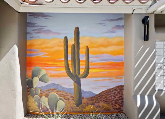 A desert scene with a cactus in the foreground.