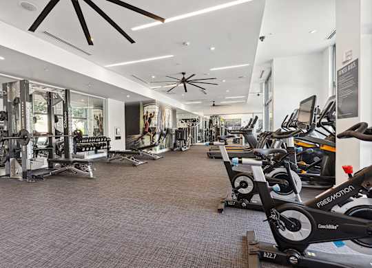 a spacious fitness center with cardio machines and other exercise equipment