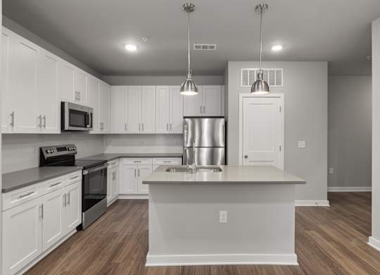 A modern kitchen with white cabinets and stainless steel appliances.