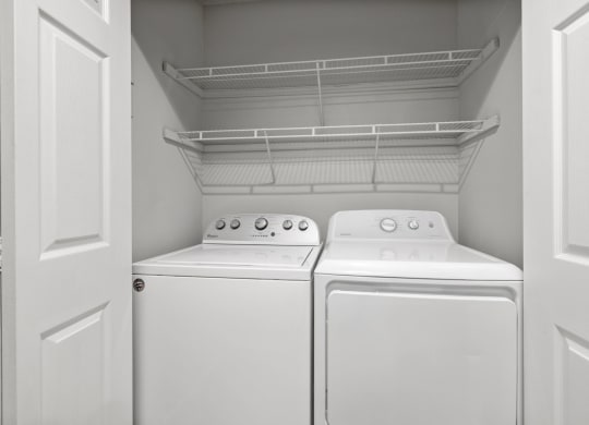 an empty laundry room with two washes and a dryer