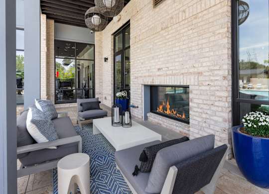 A modern patio with a fireplace and seating area.