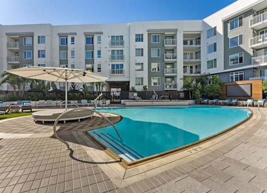 A large swimming pool in front of apartment buildings.