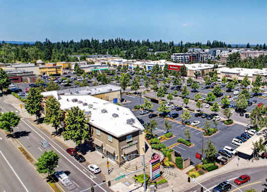 A parking lot with cars and a building in the background.