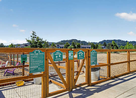 A wooden fence with green signs on it.