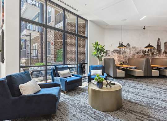 a large living room with blue couches and chairs and a large window