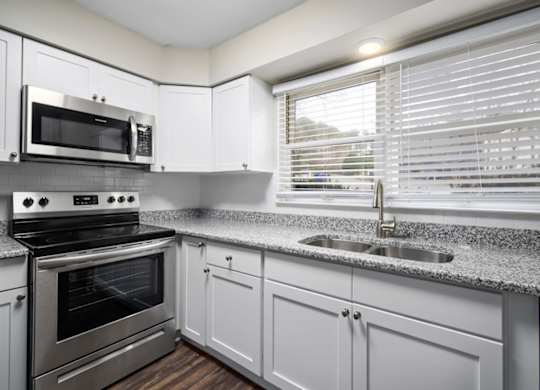 A modern kitchen with a stainless steel oven and microwave.