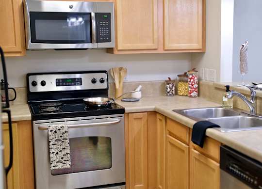 a kitchen with wooden cabinets and stainless steel appliances