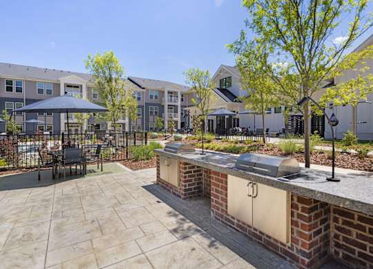 A patio area with a table and chairs is surrounded by apartment buildings.