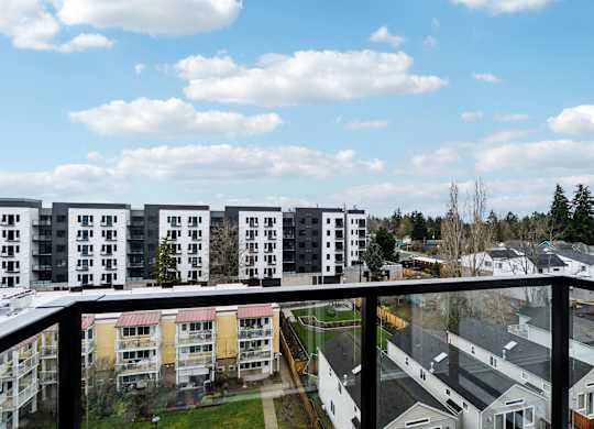 A view from a balcony overlooking apartment buildings and a parking lot at Ion Town Center, Shoreline, WA