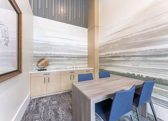 A conference room with a wooden table and blue chairs.