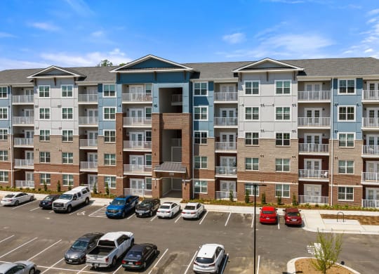 a large apartment building with a parking lot in front of it