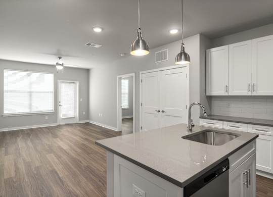 A kitchen with a sink, cabinets, and a window.
