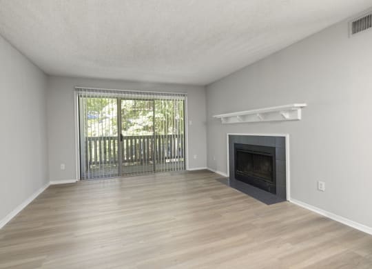 an empty living room with a fireplace and a window