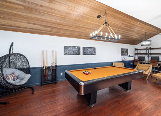 a game room with a pool table and a chandelier