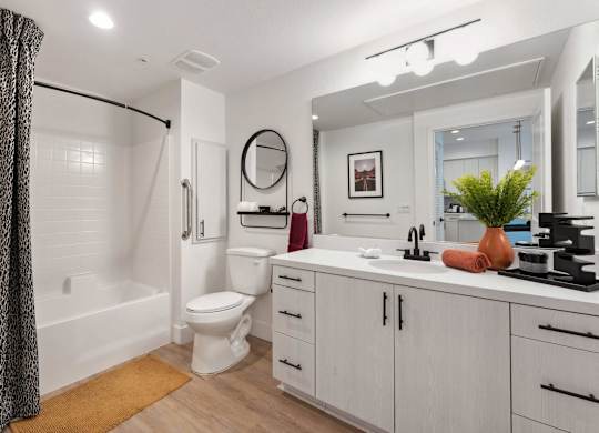A bathroom with a white toilet, sink, and a mirror.