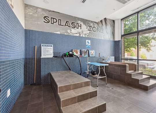 the entrance to thesplash zone with a bench and a table with a water hose