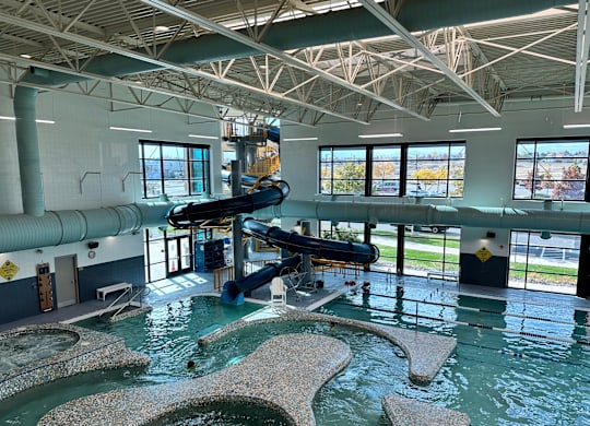 A large indoor water park with a slide and a pool.