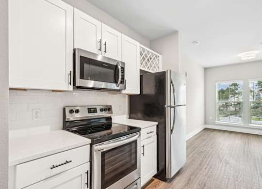 a kitchen with white cabinets and stainless steel appliances