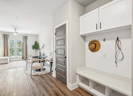 a living room with a door to a dining room and a table