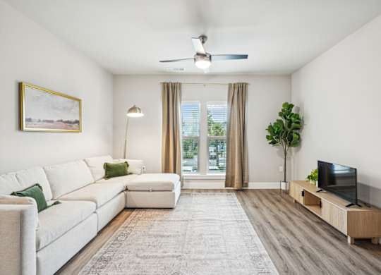 a living room with a white couch and a tv