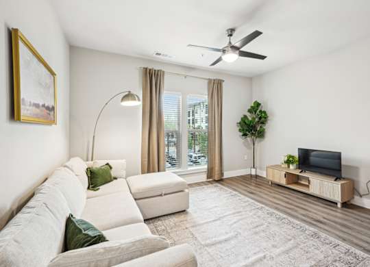 a living room with a white couch and a ceiling fan