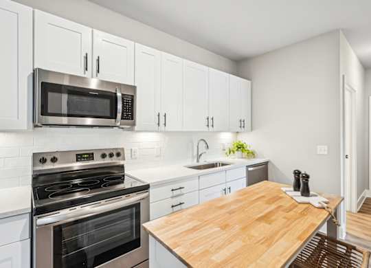 a modern kitchen with stainless steel appliances and a wooden table  and a floating island