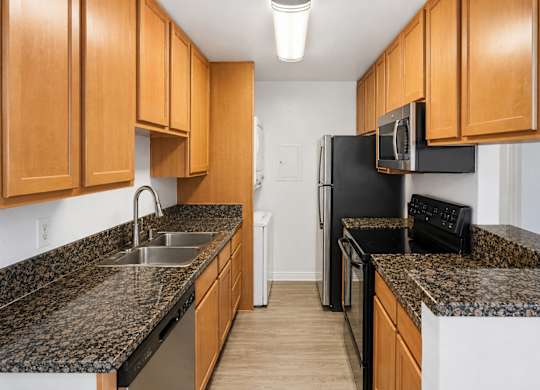 A kitchen with black appliances and wooden cabinets.