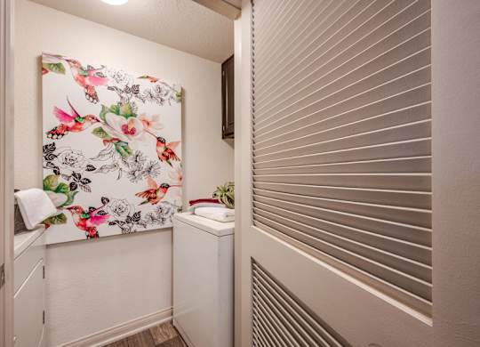 A small bathroom with a floral print towel hanging on the wall.