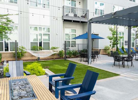 A patio with blue chairs and a table.
