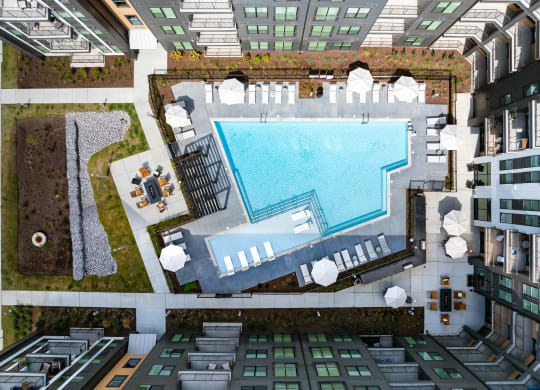 an aerial view of a swimming pool in the middle of an apartment building