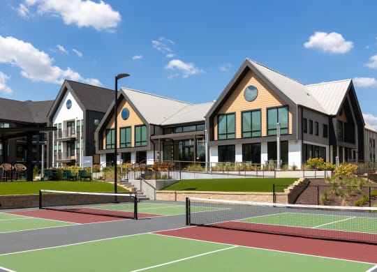 a view of a building with tennis courts in front of it