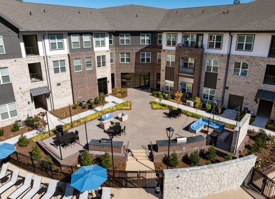an aerial view of a courtyard with tables and umbrellas